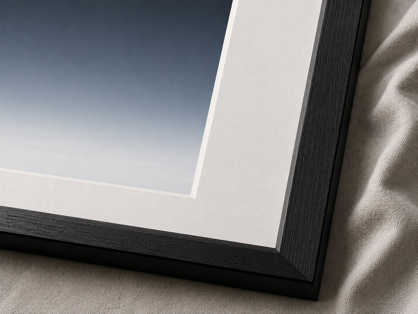 Large black and white fine art photograph above a sofa in a quiet contemporary living room with soft light and a bright central opening.